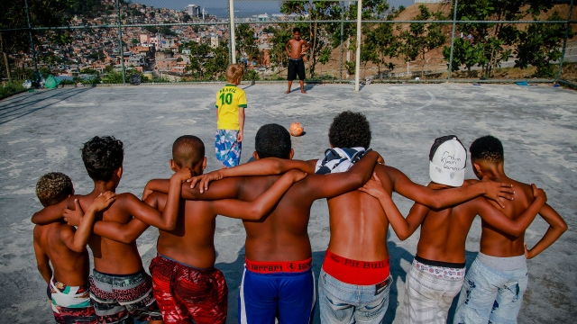 Meninos jogando bola em quadra do Complexo do Alemão, RJ. Detalhe de foto de Bruno Itan