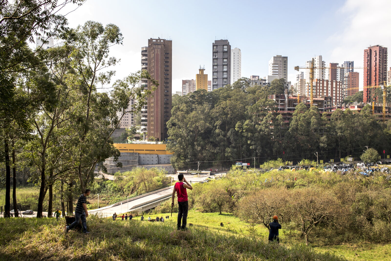 Integrante da ocupação que ficou conhecida como Copa do Povo, organizada pelo Movimento dos Trabalhadores Sem-Teto (MTST), avisa os companheiros sobre um possível conflito com o proprietário do terreno. Itaquera, São Paulo, 2014, da série Offside Brazil. 30 x 42 cm. Foto de André Vieira. Coleção de Arte Contemporânea / Acervo IMS 