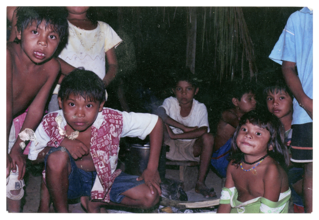Djonatan Suru&iacute;, Manasses Suru&iacute;, Natanael Suru&iacute;, Luan Suru&iacute;, Natalia Suru&iacute;, Pabab Suru&iacute; e outras crian&ccedil;as Paiter Suru&iacute;, Aldeia Lapetanha, c. 2001 Antes da eletricidade chegar na aldeia, a noite nos reun&iacute;amos em torno do fogo para ouvir as narrativas dos mais velhos. As hist&oacute;rias, como de quando os animais foram humanos e sobre o castigo de Palob a Palob Leregu, chamavam a aten&ccedil;&atilde;o das crian&ccedil;as e dos mais jovens. O conto do terr&iacute;vel Gerbay, o inimigo da floresta, deixava todos com muito medo, a ponto de nenhuma crian&ccedil;a sair para brincar na escurid&atilde;o da noite. Autoria desconhecida. (Legenda por Coletivo Lakapoy).  Fotografias em pigmento mineral sobre papel de algod&atilde;o impressas em 2025. 77 x 53,7 cm. Cole&ccedil;&atilde;o de Arte Contempor&acirc;nea / Acervo IMS 